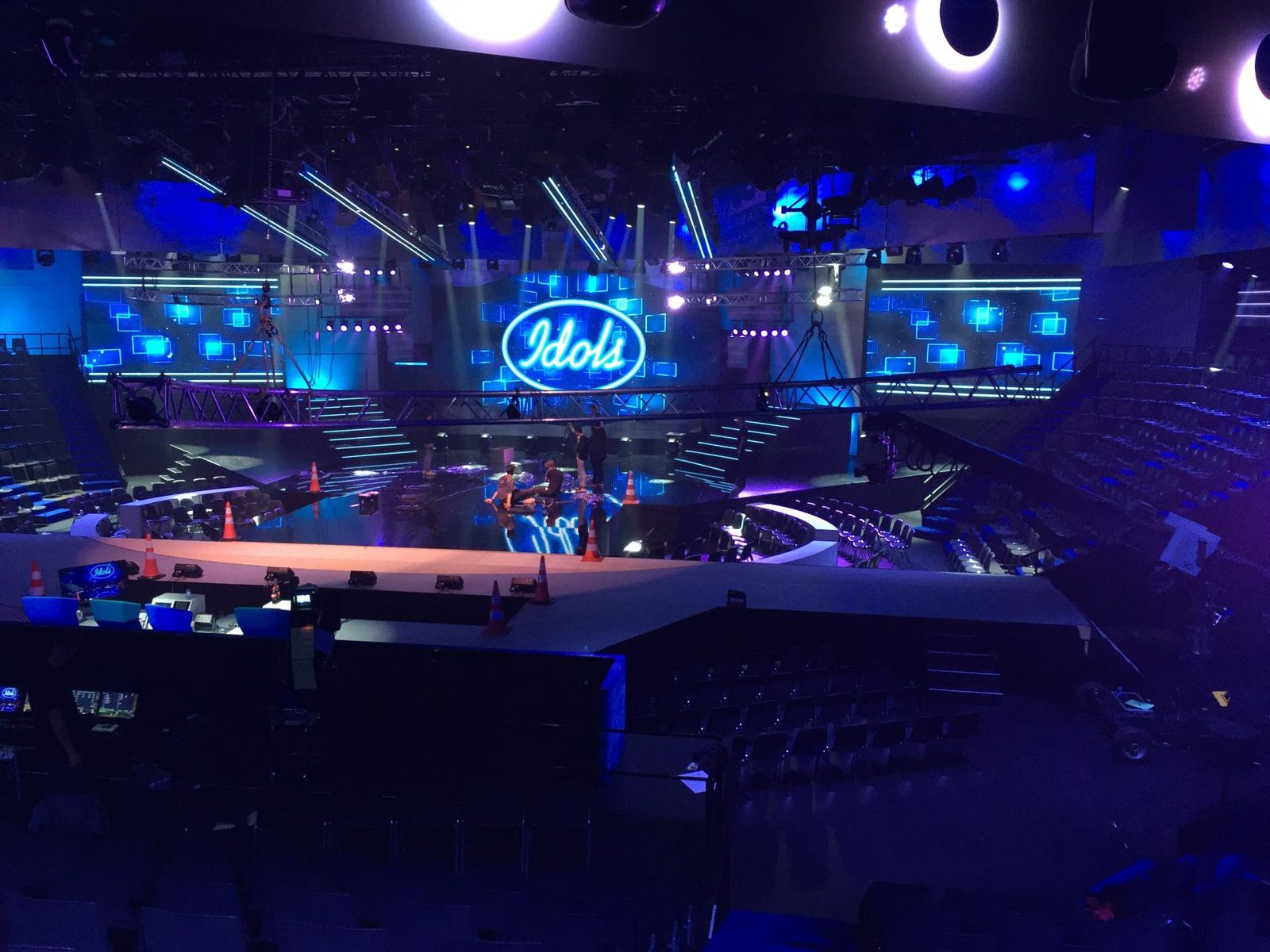 Het podium van Idols met het neonlogo, tijdens de opbouw in een lege zaal